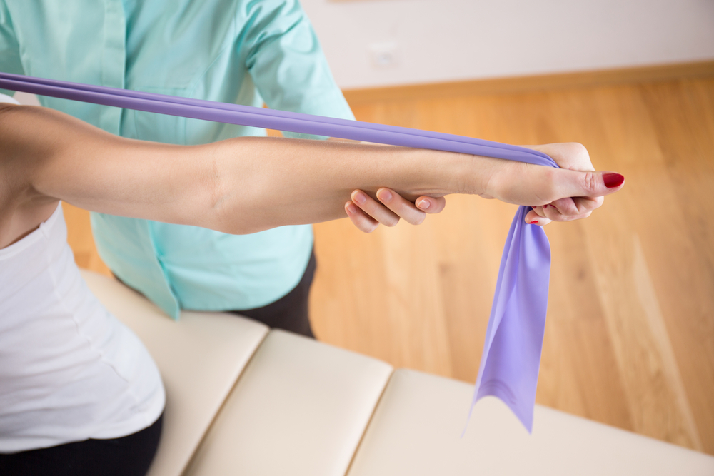 Close-up of patient doing exercise with elastic band Close-up of patient doing exercise with elastic band