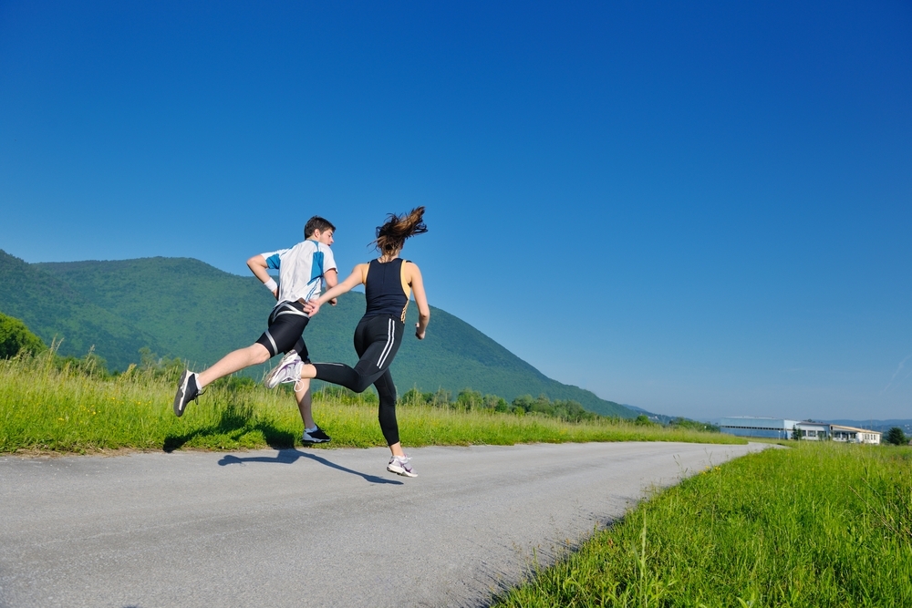 Young couple jogging in park at morning. Health and fitness.